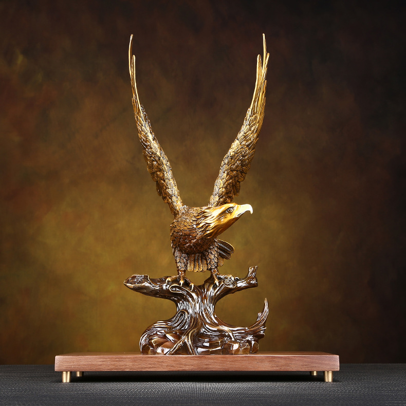 Golden eagle figurine standing on a branch, symbolizing power and freedom