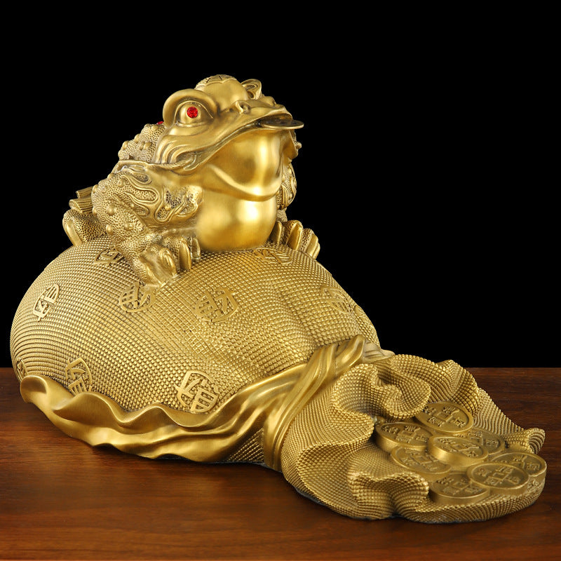 Side view of the golden toad, showcasing detailed carvings and a bag overflowing with gold ingots.